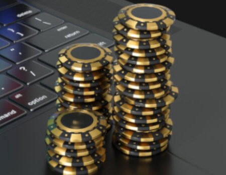 Poker chips stacked on top of a laptop symbolizing online gambling